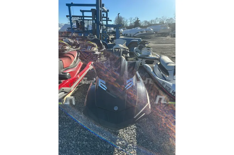 Slide: The Image of 2014 Yamaha WaveRunner FX Cruiser SVHO parked on gravel lot with other watercraft. - 2