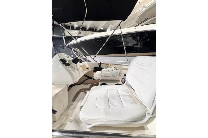 Slide: The Image of 2011 Boston Whaler 160 Super Sport interior with white seating and steering console. - 4