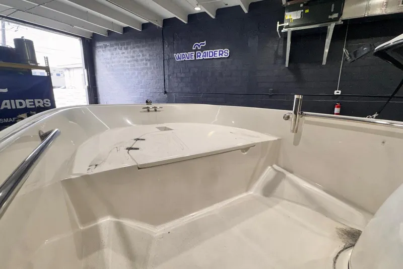 Slide: The Image of 2011 Boston Whaler 160 Super Sport boat interior in showroom with Wave Raiders sign. - 6