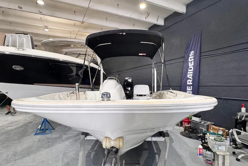 Slide: The Image of 2011 Boston Whaler 160 Super Sport boat in indoor storage, with black canopy. - 8