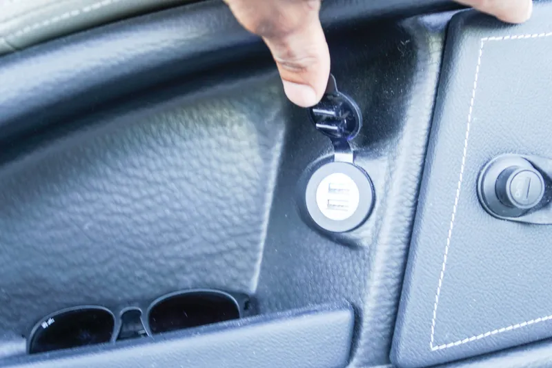 Slide: The Image of USB ports in 2026 Crownline 288 SS boat interior, with sunglasses nearby. - 12