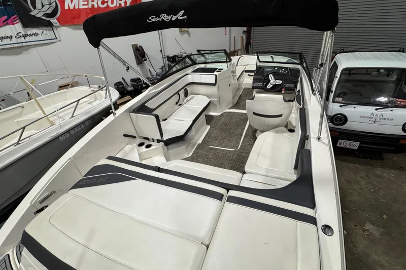 Slide: The Image of 2016 Sea Ray SPX 210 Outboard boat interior with seating and steering wheel in showroom. - 16