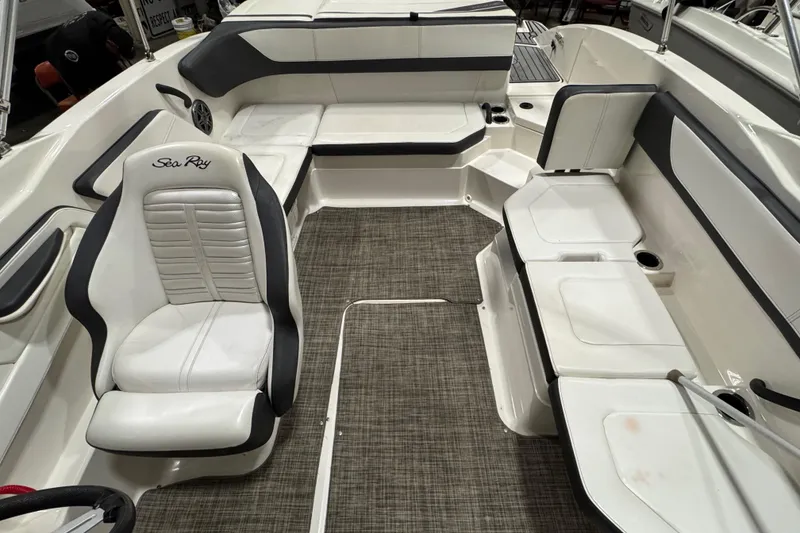 Slide: The Image of 2016 Sea Ray SPX 210 Outboard interior with white seating and gray flooring. - 18