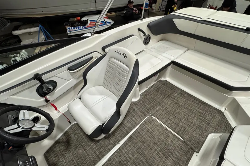 Slide: The Image of 2016 Sea Ray SPX 210 Outboard boat interior with steering wheel and seating area. - 19