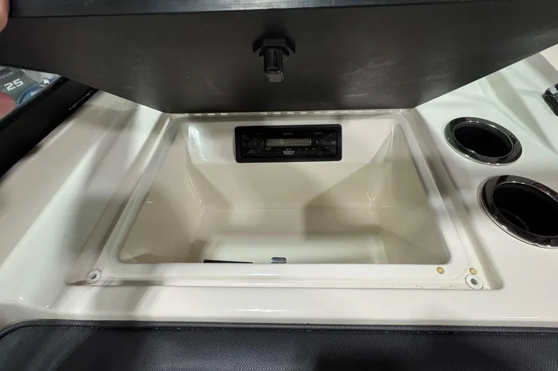 Slide: The Image of 2016 Sea Ray SPX 210 Outboard storage compartment with stereo and cup holders. - 24