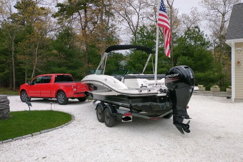 Slide: The Image of 2016 Sea Ray SPX 210 Outboard boat on trailer, parked beside red truck. - 4