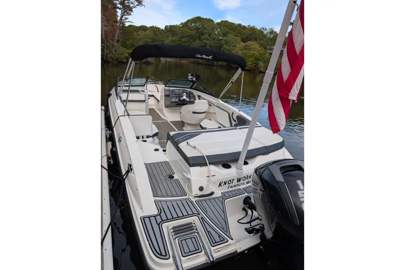 Slide: The Image of 2016 Sea Ray SPX 210 Outboard boat docked, featuring spacious seating and American flag. - 5