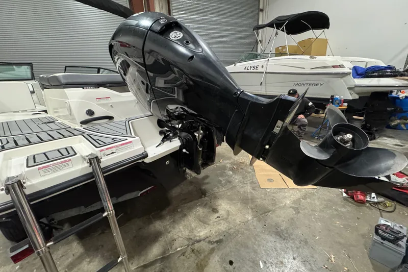 Slide: The Image of 2016 Sea Ray SPX 210 Outboard boat in a garage, showcasing the motor and deck. - 9