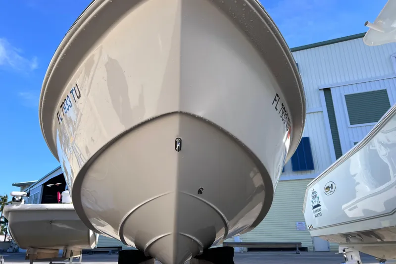 Slide: The Image of 2024 Everglades 243 Center Console boat, docked with clear blue sky background. - 12