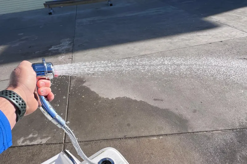 Slide: The Image of Hand holding a hose spraying water on concrete, Everglades 243 Center Console, 2024. - 32