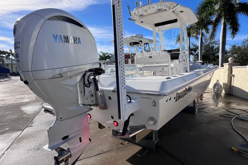 Slide: The Image of 2024 Everglades 243 Center Console boat with Yamaha engine, docked under clear skies. - 4