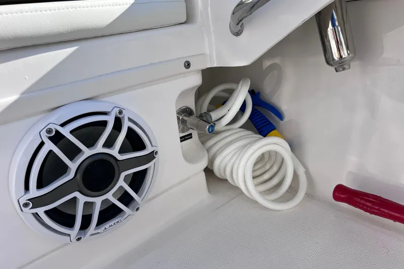 Slide: The Image of 2024 Everglades 243 Center Console boat interior with speaker and coiled hose. - 79