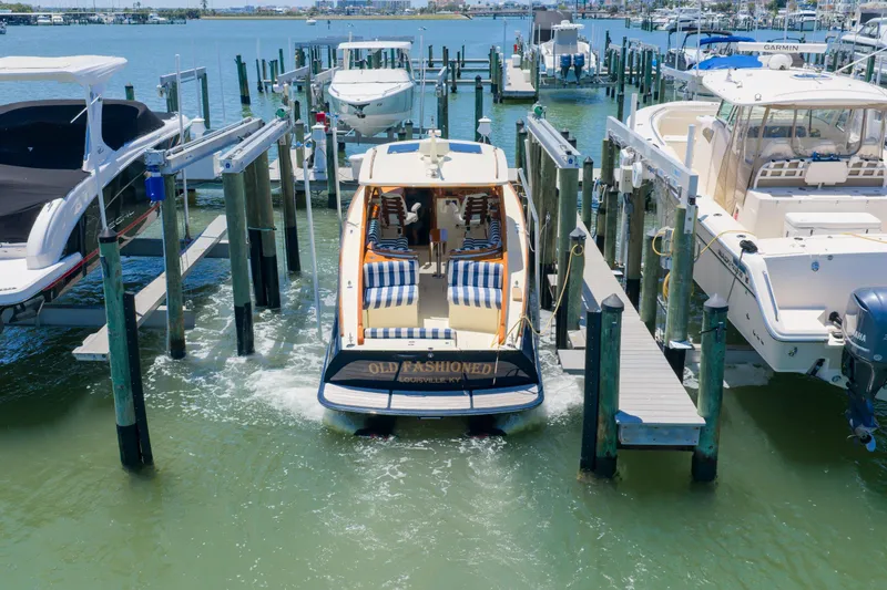 Slide: The Image of 2020 Hinckley Picnic Boat 34 MKII docked at marina with striped seating. - 1