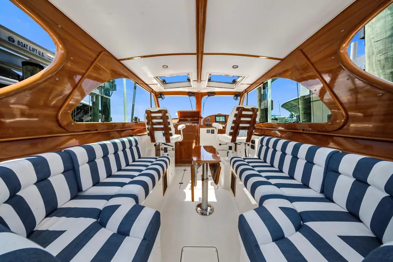 Slide: The Image of Interior of 2020 Hinckley Picnic Boat 34 MKII with striped seating and wooden accents. - 10