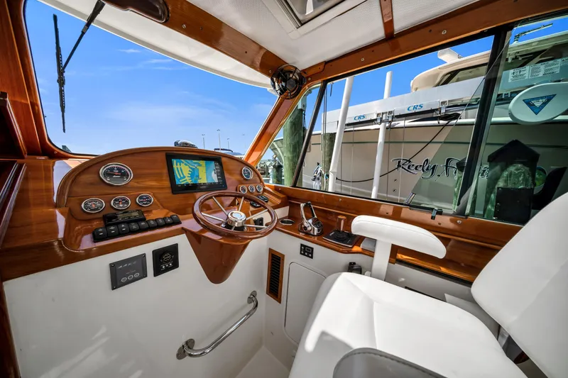 Slide: The Image of Helm of 2020 Hinckley Picnic Boat 34 MKII with wooden dashboard and navigation controls. - 11