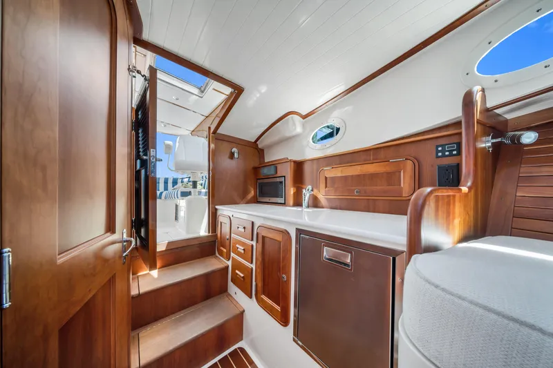 Slide: The Image of Interior of 2020 Hinckley Picnic Boat 34 MKII with elegant wood finish and modern amenities. - 13