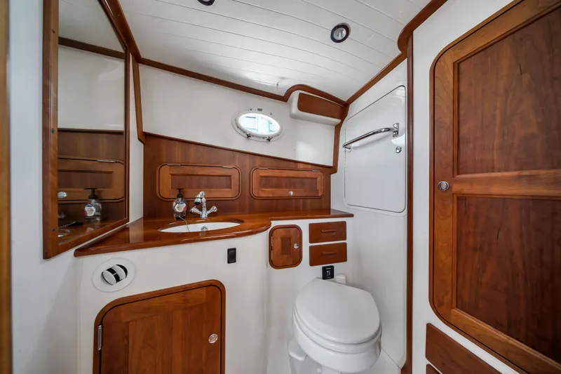 Slide: The Image of Luxurious 2020 Hinckley Picnic Boat 34 MKII bathroom with wood accents and modern fixtures. - 16