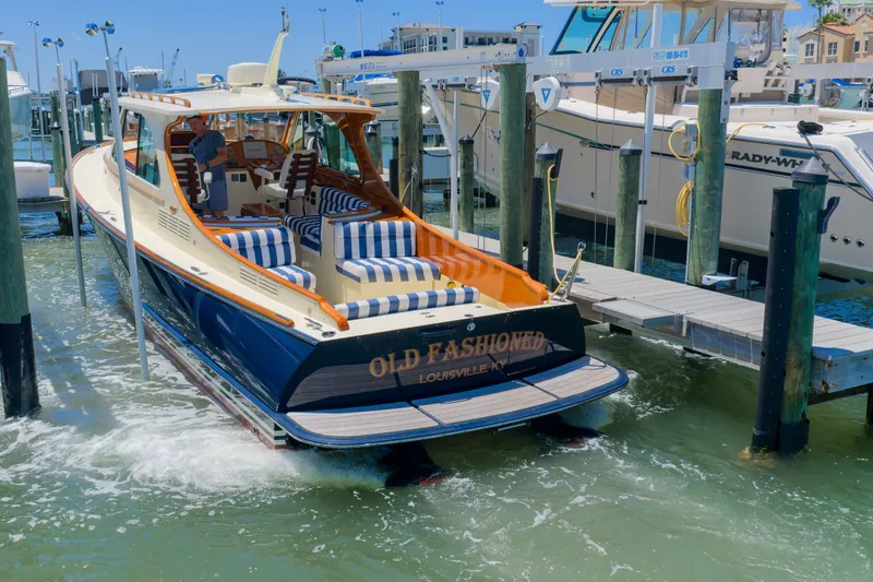 Slide: The Image of 2020 Hinckley Picnic Boat 34 MKII docked, featuring striped seating and elegant design. - 5