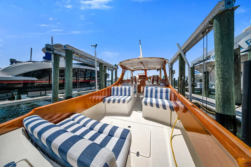Slide: The Image of 2020 Hinckley Picnic Boat 34 MKII with striped seating at a marina dock. - 7