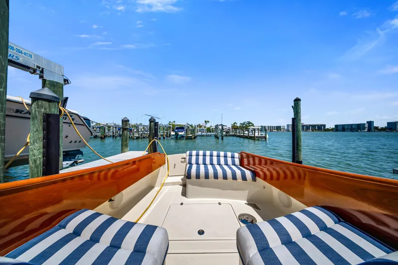 Slide: The Image of 2020 Hinckley Picnic Boat 34 MKII with striped seating, docked in a scenic marina. - 8