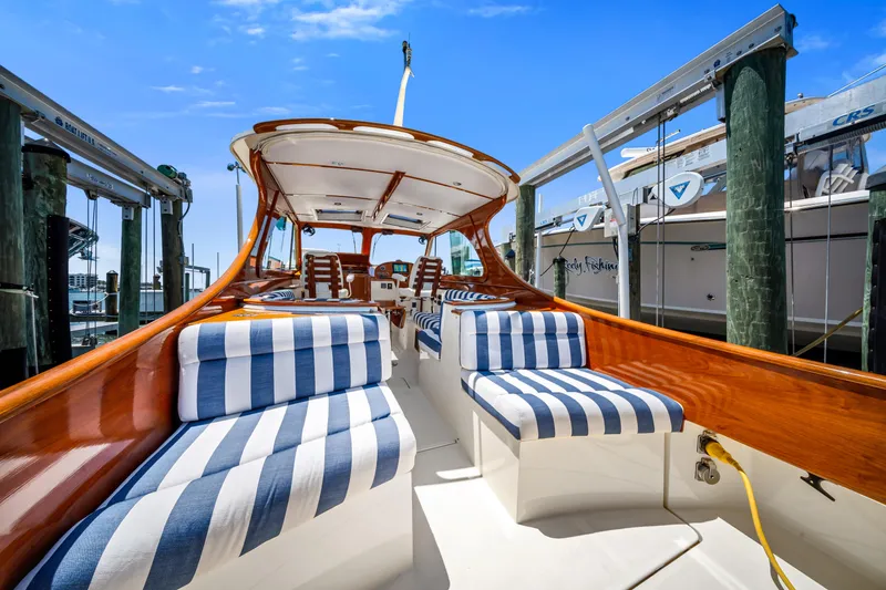 Slide: The Image of 2020 Hinckley Picnic Boat 34 MKII with striped seating, docked under a clear blue sky. - 9