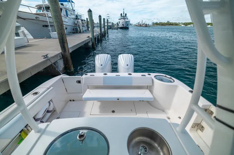 Slide: The Image of 2023 Robalo R302 Center Console boat docked at marina with dual engines. - 10