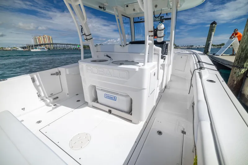 Slide: The Image of 2023 Robalo R302 Center Console boat docked, showcasing spacious deck and modern design. - 12