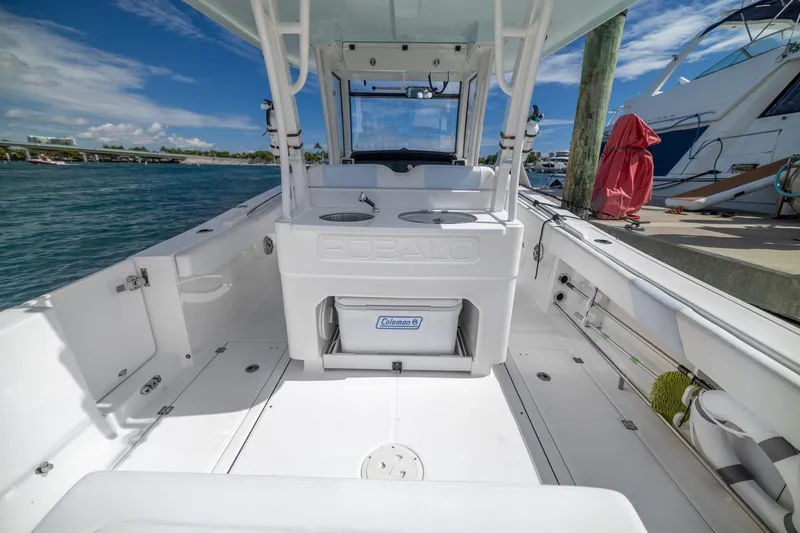 Slide: The Image of 2023 Robalo R302 Center Console boat interior at dock, featuring spacious deck and storage. - 13