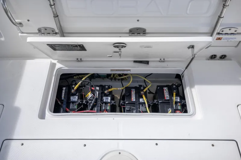 Slide: The Image of 2023 Robalo R302 Center Console boat battery compartment with multiple batteries and wiring. - 14