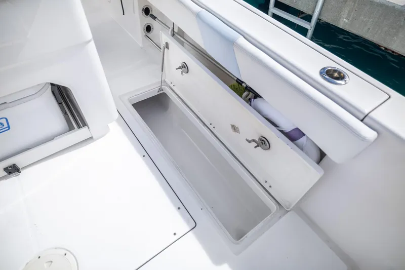 Slide: The Image of 2023 Robalo R302 Center Console boat storage compartment open on deck. - 15