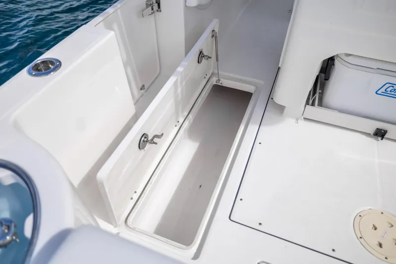 Slide: The Image of 2023 Robalo R302 Center Console boat storage compartment and seating area. - 16