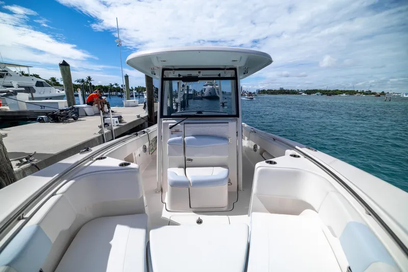 Slide: The Image of 2023 Robalo R302 Center Console boat docked, showcasing spacious seating and ocean view. - 24