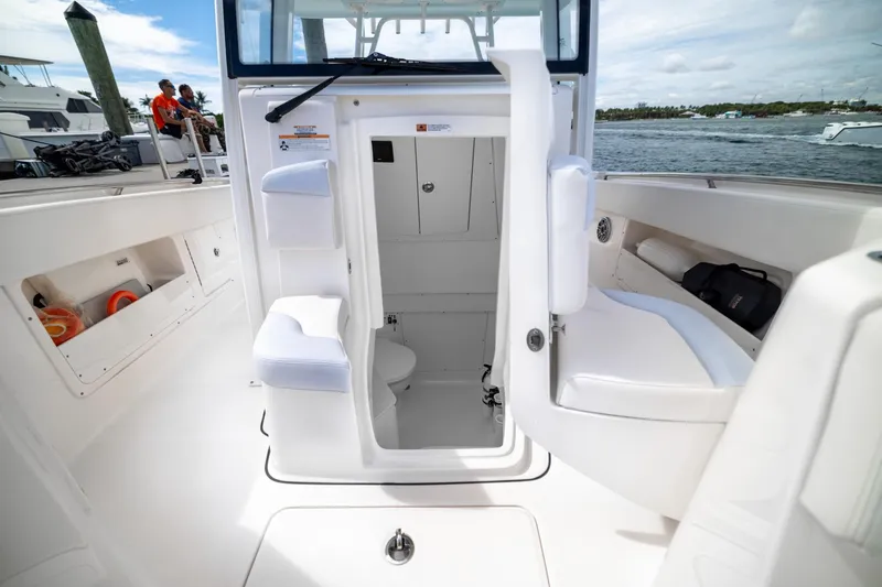 Slide: The Image of 2023 Robalo R302 Center Console boat interior with open cabin door and seating. - 26