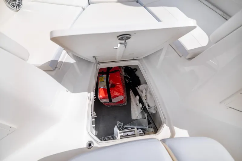 Slide: The Image of 2023 Robalo R302 Center Console storage compartment with safety gear and equipment. - 28