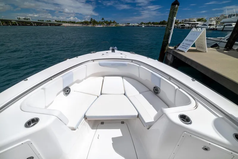 Slide: The Image of 2023 Robalo R302 Center Console boat with spacious seating at the bow, docked by the water. - 32