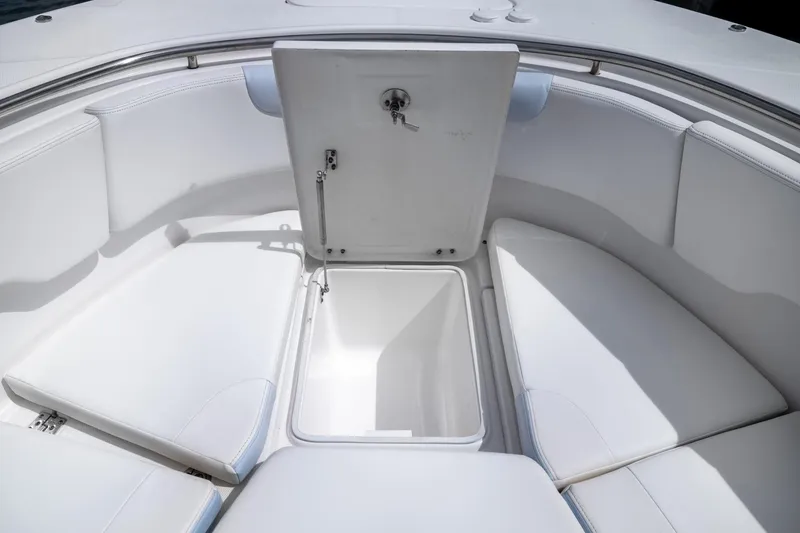 Slide: The Image of 2023 Robalo R302 Center Console boat with open storage compartment and cushioned seating. - 36