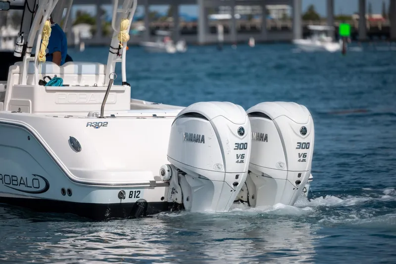 Slide: The Image of 2023 Robalo R302 Center Console with twin Yamaha 300 V6 engines on water. - 6