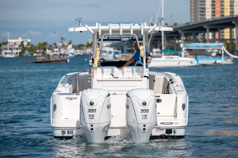 Slide: The Image of 2023 Robalo R302 Center Console boat with dual Yamaha 300 V6 engines on water. - 7