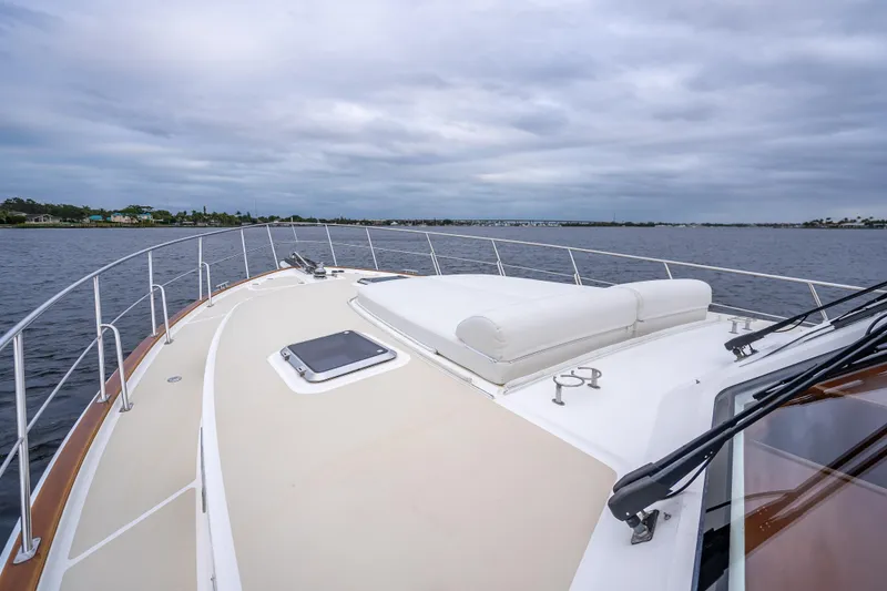 Slide: The Image of 2014 Grand Banks 50 Eastbay SX yacht deck with cushioned seating, cruising on calm waters. - 22