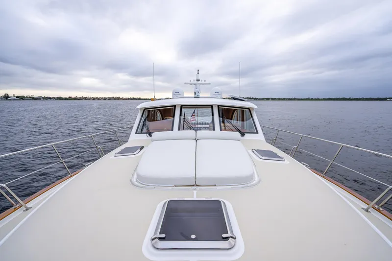 Slide: The Image of 2014 Grand Banks 50 Eastbay SX yacht on calm waters under cloudy skies. - 24