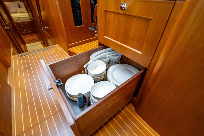 Slide: The Image of Wooden drawer with plates inside a 2014 Grand Banks 50 Eastbay SX yacht interior. - 38