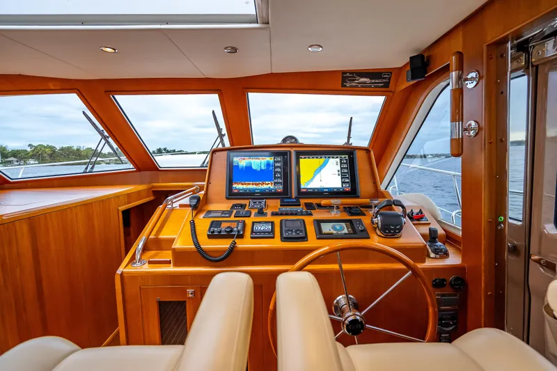 Slide: The Image of Helm of 2014 Grand Banks 50 Eastbay SX with navigation screens and wooden finish. - 44