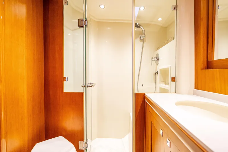 Slide: The Image of Luxurious bathroom in 2014 Grand Banks 50 Eastbay SX yacht with wooden cabinetry and glass shower. - 65
