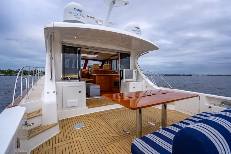 Slide: The Image of 2014 Grand Banks 50 Eastbay SX yacht with elegant deck and seating, cruising on open water. - 8