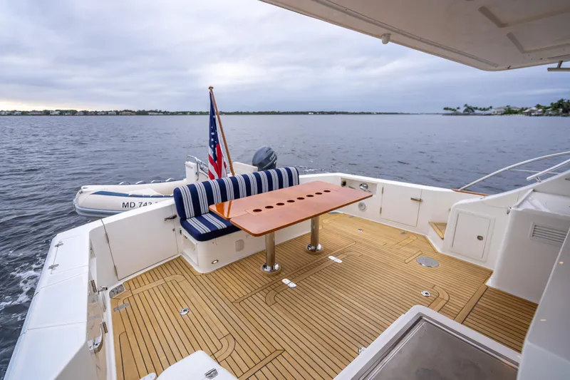 Slide: The Image of 2014 Grand Banks 50 Eastbay SX yacht deck with seating and table, overlooking calm waters. - 9