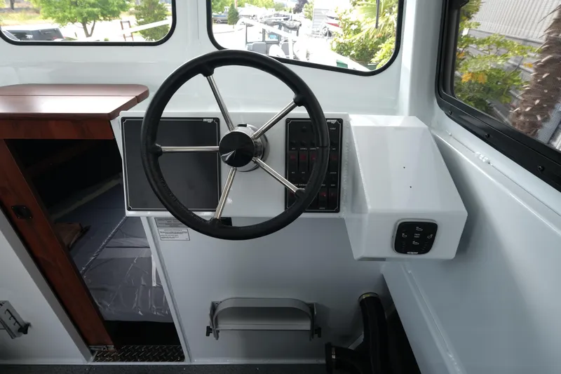 Slide: The Image of 2025 Hewescraft 240 Pacific Cruiser helm with steering wheel and control panel. - 14