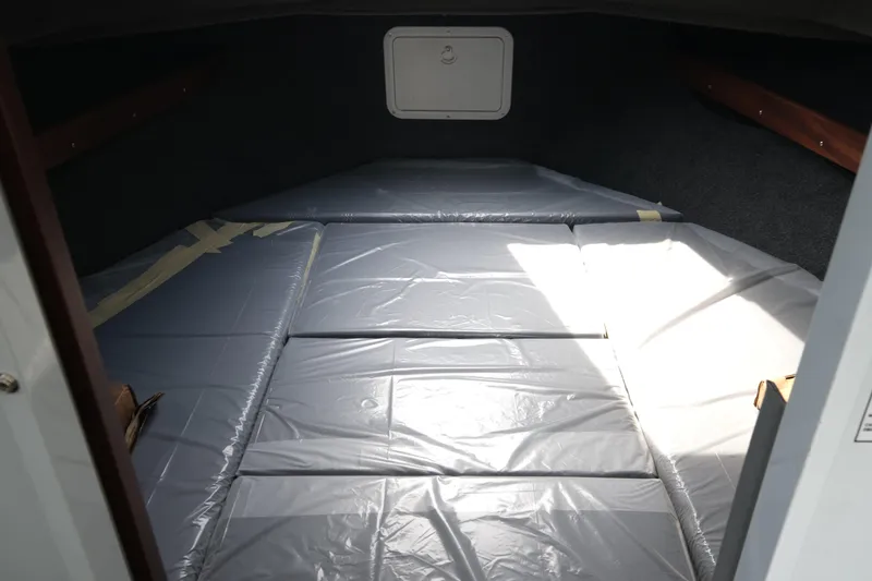 Slide: The Image of 2025 Hewescraft 240 Pacific Cruiser interior cabin with padded sleeping area. - 15