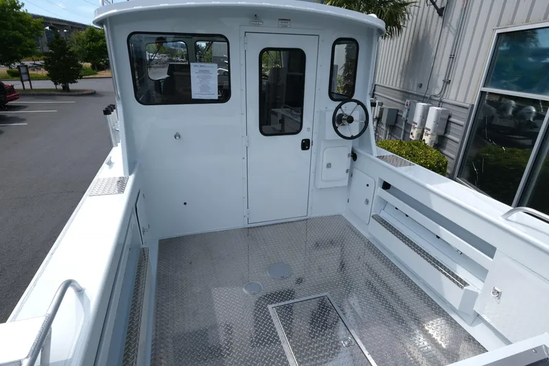 Slide: The Image of 2025 Hewescraft 240 Pacific Cruiser boat deck with steering wheel and metal flooring. - 7