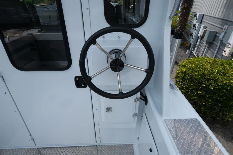 Slide: The Image of Steering wheel of 2025 Hewescraft 240 Pacific Cruiser boat, featuring sleek design and metal accents. - 9