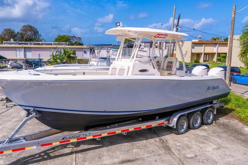 Slide: The Image of 2017 Cobia 296 Center Console boat on trailer, parked outdoors under blue sky. - 10